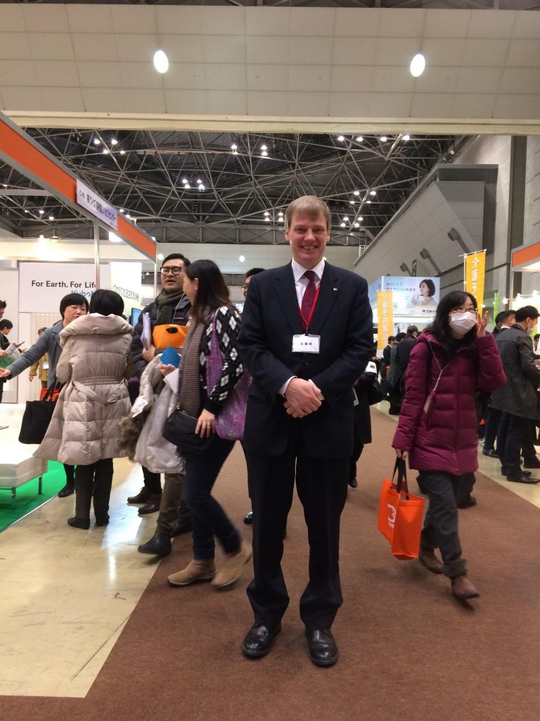 統合医療展のセミナーであふれる人だかりを避けて撮影に応じるUBMジャパンのクリストファー・イブ社長